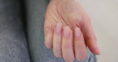 Kadın nazikçe avuç içini açar ve reçeteli küçük kalp şeklindeki tableti gösterir. Zayıf kalpten kaynaklanan rahatsızlığı gidermek için kadın girişimleri. Yavaş çekim