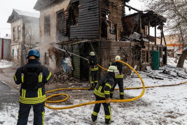 Vovchansk, Kharkiv Oblast  Ukraine - February 01 2023: Firefighters extinguish fire blown up by a mine during Russian shelling of a peaceful town in Ukraine