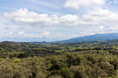 Yunanistan 'daki İyon Denizi' ndeki Korfu adasının güzel bir manzarası. Bir sürü yeşil bitkisi olan dağlar. Adanın üzerinde kalın bulutlar.