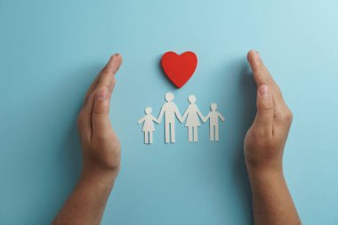 Aile kâğıdını tutan eller, hayat sigortası, sosyal uzaklık konsepti, covid19, mavi renkli arka plan, aile koruması