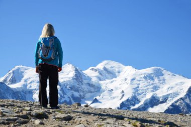 Hiker looking at the Mont Blanc from the summit of Le Brevent. French Alps, Chamonix, France. clipart