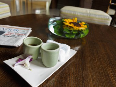 Hoş geldin içkisi. Masaya yüzünü silmek için serin bir bez.