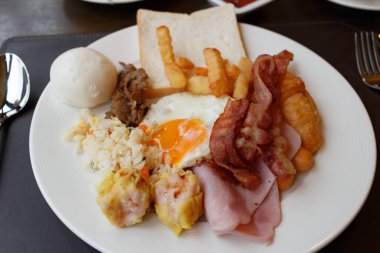 Domuz pastırmalı Amerikan kahvaltısı beyaz tabakta kızarmış pirinç.