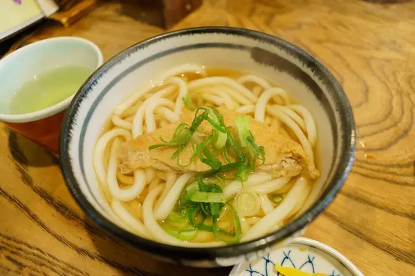Üstü dilimlenmiş soya peynirli Japon eriştesi.