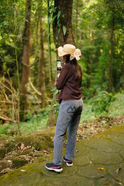 Ormanda cep telefonuyla fotoğraf çeken Asyalı kadınlar.