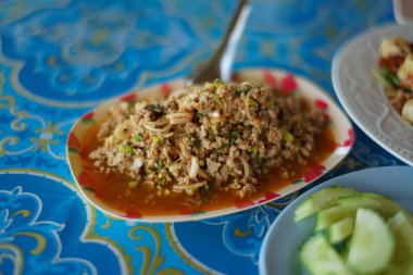Baharatlı domuz salatası mavi masada.