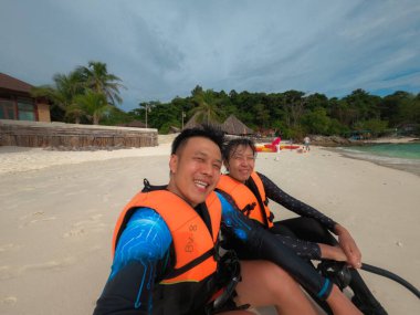 Sahilde can yeleği giyen Asyalı çift.