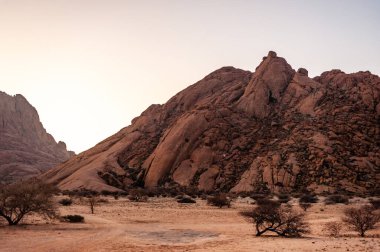 Namibya çölünde, Spitzkoppe yakınlarında, gün batımında kaya oluşumları.