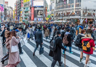 Tokyo, Japonya - 8 Ocak 2020. Birçok insan işlek caddelerde yürüyor ve gün batımında ünlü Shibuya Geçidi 'nden geçiyor. Shibuya Tokyo 'daki en ünlü kavşaklardan biridir..