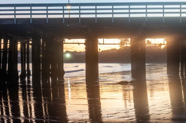 夕日はサンタクルーズ埠頭の後ろの水に反射されています — ストック写真