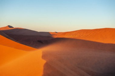 Namibya Sossusvlei kumullarının dış görüntüsü ünlü kum tepeciklerinin yakınında, güneş doğarken.