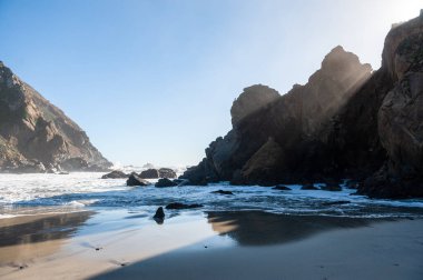 Late afternoon impression of Pfeiffer beach, California on a bright sunny afternoon as the sun is about to set.