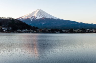 Mount Fuji on a bright winter morning, as seen from across lake Kawaguchi, and the nearby town of Kawaguchiko.