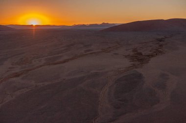 Namibya Sossusvlei kumullarının dış görüntüsü ünlü kum tepeciklerinin yakınında, güneş doğarken.