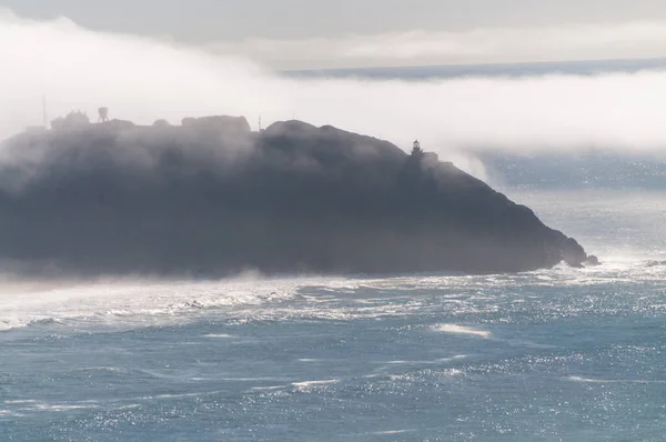 A layer of fog is rolling out over Point Sur, California.
