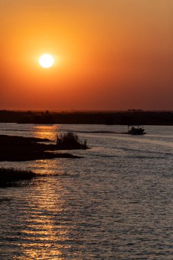 Telephoto shot of the setting sun over the chobe river on a bright winter afternoon in Botswana.