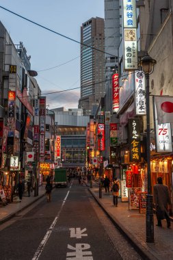 Tokyo, Japonya - 8 Ocak 2020. Birçok insan işlek caddelerde yürüyor ve gün batımında ünlü Shibuya Geçidi 'nden geçiyor. Shibuya Tokyo 'daki en ünlü kavşaklardan biridir..