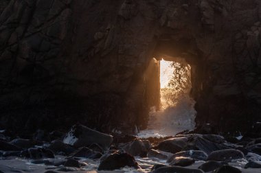 Detail of the Keyhole arch at Pfeiffer beach, with the setting sun to be just behind it.