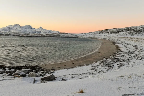 長い冬の間の短い黄金の時間の間に 険しい山々と雪に覆われた北極の海岸を強調した風景が撮影されました — ストック写真