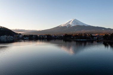 Mount Fuji on a bright winter morning, as seen from across lake Kawaguchi, and the nearby town of Kawaguchiko.