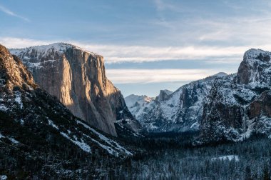 Sabah güneşinin ilk ışıkları Yosemite Ulusal Parkı 'ndaki Sierra dağlarındaki kayalardan yansıyor. Karla kaplı yeni bir gün..