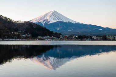 Mount Fuji on a bright winter morning, as seen from across lake Kawaguchi, and the nearby town of Kawaguchiko.