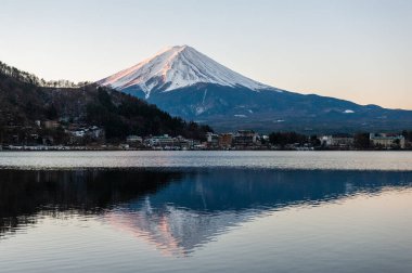 Mount Fuji on a bright winter morning, as seen from across lake Kawaguchi, and the nearby town of Kawaguchiko.