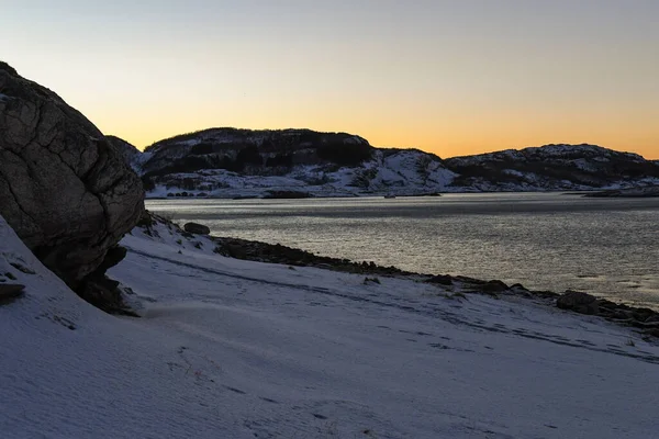 長い冬の間の短い黄金の時間の間に 険しい山々と雪に覆われた北極の海岸を強調した風景が撮影されました — ストック写真