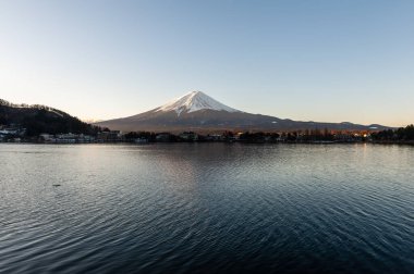 Mount Fuji on a bright winter morning, as seen from across lake Kawaguchi, and the nearby town of Kawaguchiko.