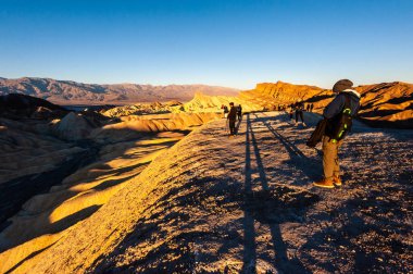 26 Aralık 2021 - İzleyiciler Zabriskie Point, Ölüm Vadisi 'nde sabahın erken saatlerinde gün doğumunu izliyorlar.