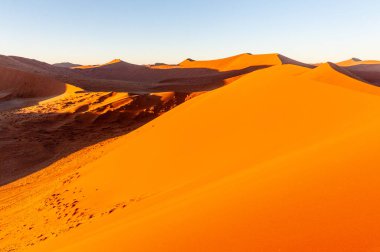 Namibya Sossusvlei kumullarının dış görüntüsü ünlü kum tepeciklerinin yakınında, güneş doğarken.