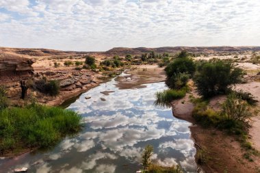 Düşük dağılmış bulutlar Güney Namibya 'daki Balık Nehri' ne yansıyor.