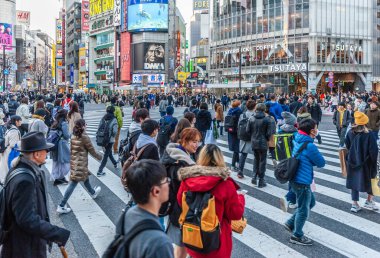 Tokyo, Japonya - 8 Ocak 2020. Birçok insan işlek caddelerde yürüyor ve gün batımında ünlü Shibuya Geçidi 'nden geçiyor. Shibuya Tokyo 'daki en ünlü kavşaklardan biridir..