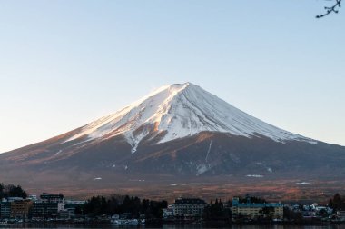 Mount Fuji on a bright winter morning, as seen from across lake Kawaguchi, and the nearby town of Kawaguchiko.