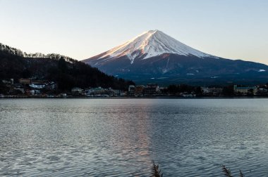 Mount Fuji on a bright winter morning, as seen from across lake Kawaguchi, and the nearby town of Kawaguchiko.