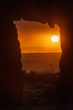 Detail of the Keyhole arch at Pfeiffer beach, with the setting sun to be just behind it.
