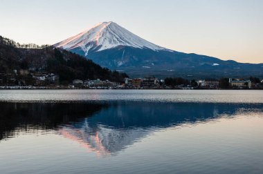 Mount Fuji on a bright winter morning, as seen from across lake Kawaguchi, and the nearby town of Kawaguchiko.