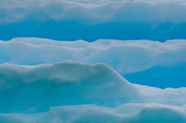 Muhteşem şekiller ve koyu mavi renkler içeren Antarktika deniz buzunun ayrıntıları.