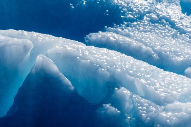 Detail of a patch of Antarctic sea ice, containing wonderous shapes and deep blue colours. clipart