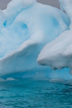 Muhteşem şekiller ve koyu mavi renkler içeren Antarktika deniz buzunun ayrıntıları.