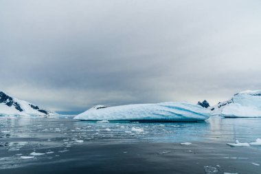 Antarktika Yarımadası 'nın engebeli dağlarının yatay olarak oluşturulmuş görüntüsü ve sudaki yansımaları. Danco Adası, Antarktika