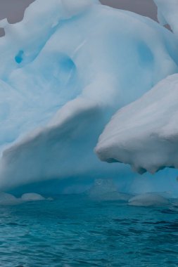 Muhteşem şekiller ve koyu mavi renkler içeren Antarktika deniz buzunun ayrıntıları.
