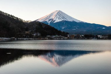 Mount Fuji on a bright winter morning, as seen from across lake Kawaguchi, and the nearby town of Kawaguchiko.