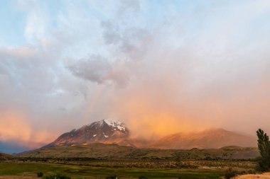 Şili, Patagonya 'daki Torres del Paine ulusal parkında sabahın erken saatlerinde dramatik renkleri ve gökkuşağını vurguluyor..