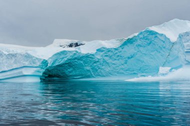 Muhteşem şekiller ve koyu mavi renkler içeren Antarktika deniz buzunun ayrıntıları.