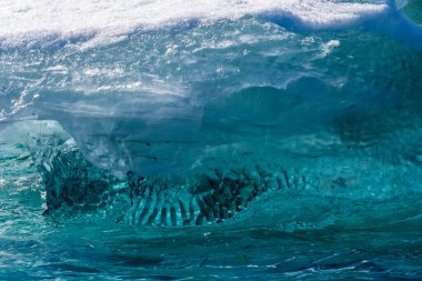 Muhteşem şekiller ve koyu mavi renkler içeren Antarktika deniz buzunun ayrıntıları.