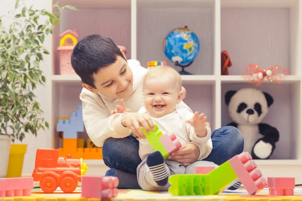 Happy Older Brother Plays Sister Colourful Building Blocks Home Kindergarten — Stock Photo, Image