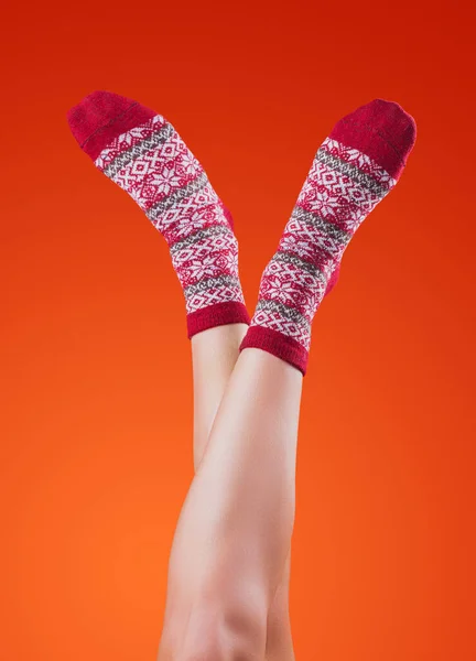 Vrouwelijke Benen Kerst Sokken Oranje Achtergrond — Stockfoto
