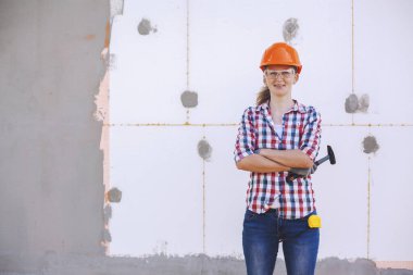 Evin poliköpükle izolasyonu. Kadın işçi, köpük plastikle izole edilmiş bir duvarın önünde duruyor.