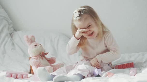おもちゃとベッドに座って泣いている小さな女の子 ビデオ ロイヤリティフリーストック映像